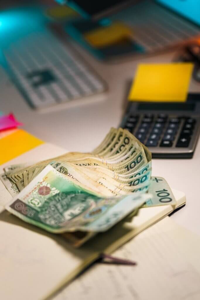 polish zloty on office desk with calculator