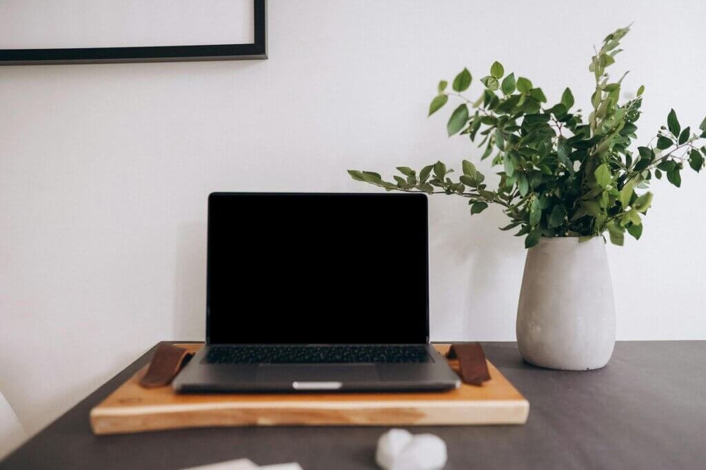 open laptop and vase standing on table