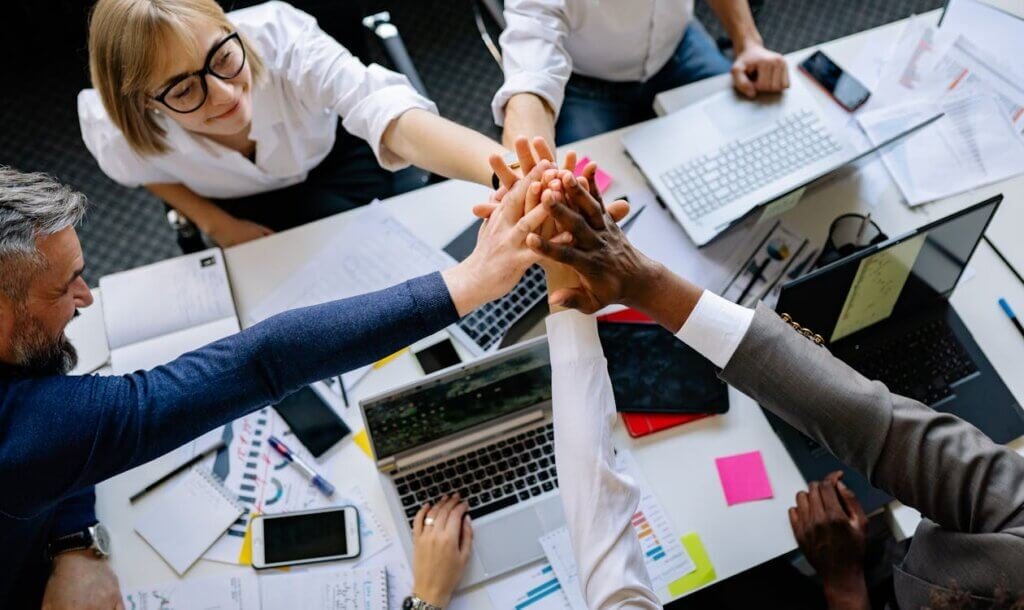 Solo vs team scaling business en ligne 2026 - collaborateurs réunis autour d'une table de travail